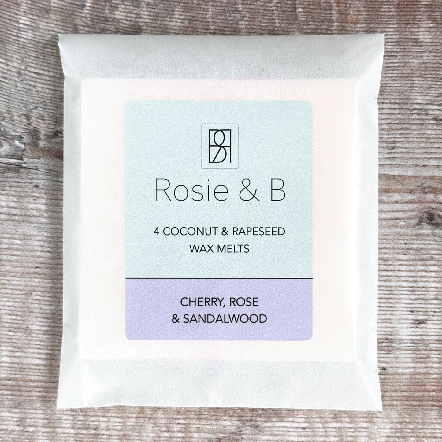 A packet of 4 Cherry, Rose & Sandalwood wax melts on a wooden background