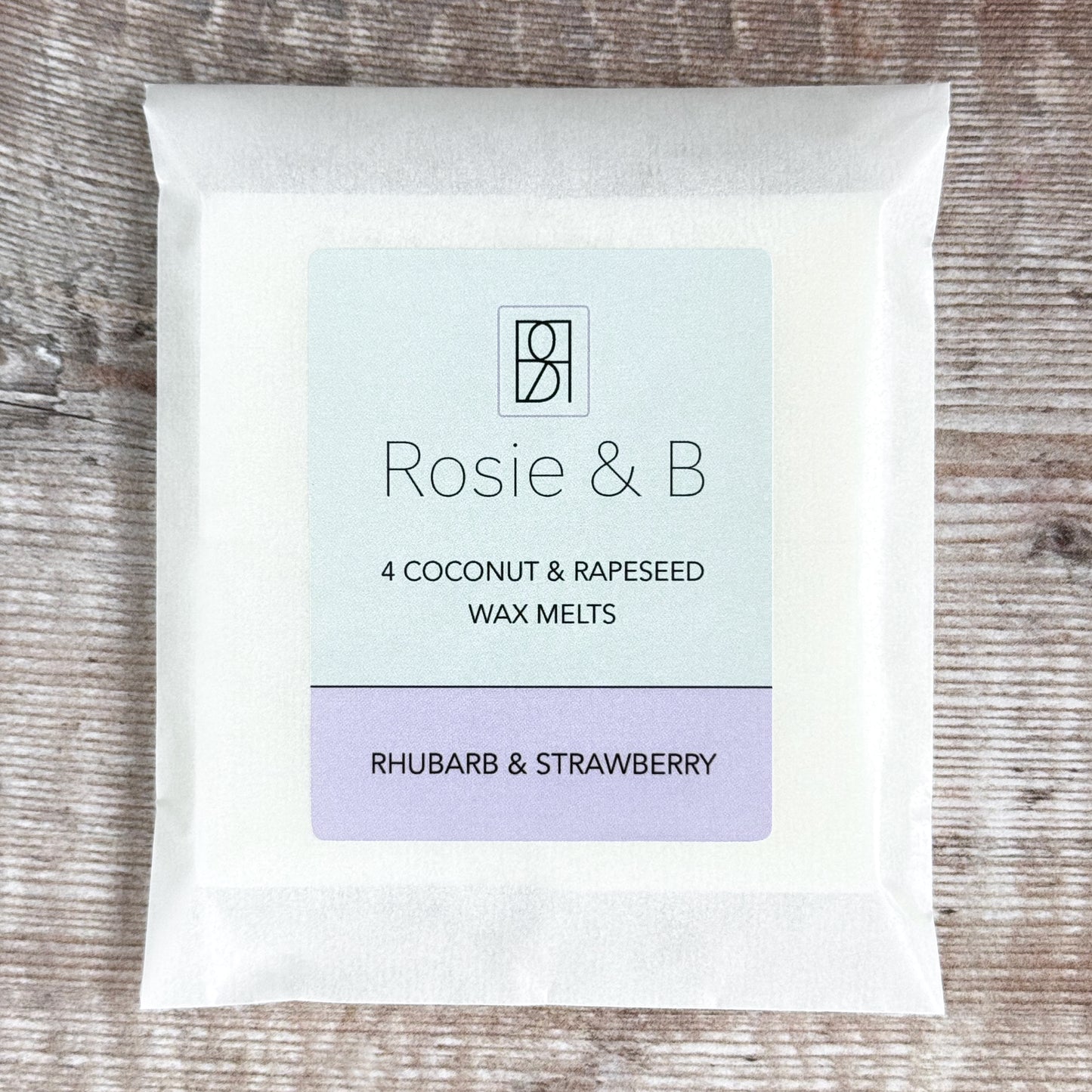 A packet of four Rhubarb & Strawberry wax melts on a wooden background