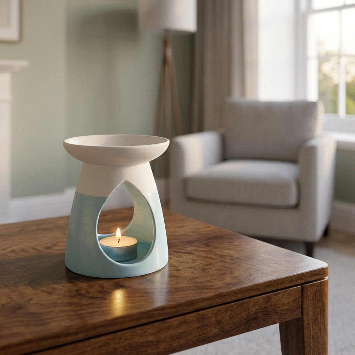 Arabella ceramic wax warmer in powder blue, with a glowing tea light, in a living room setting