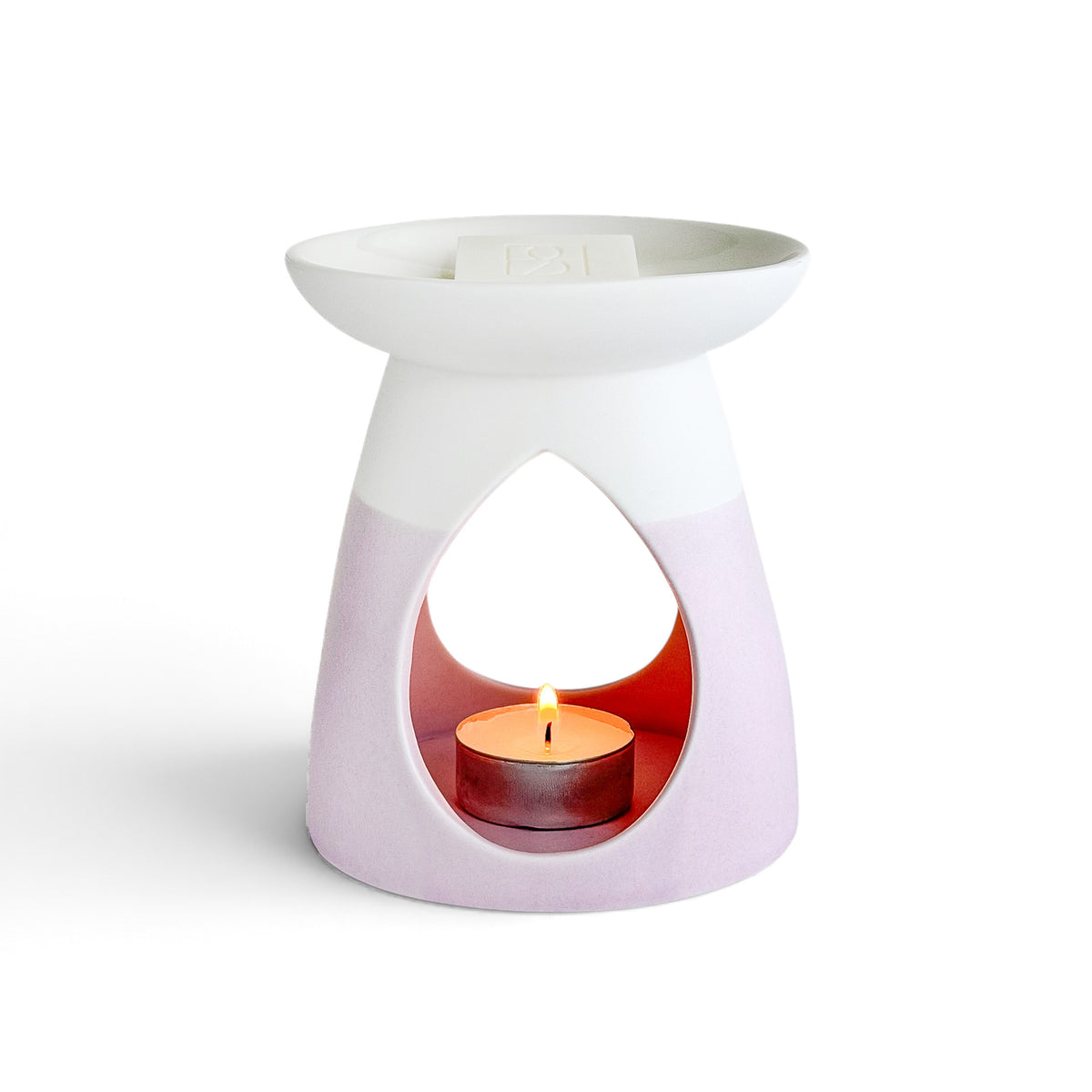 Arabella ceramic wax warmer in powder pink with a glowing tea light