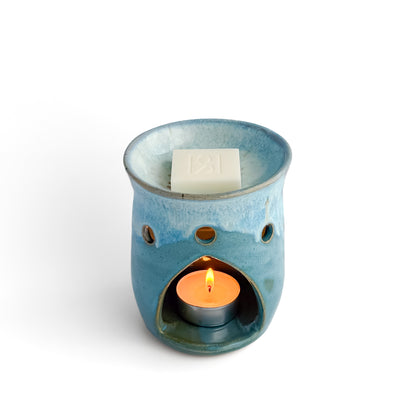 Leonore ceramic wax melt warmer in Azure Blue, with glowing tea light