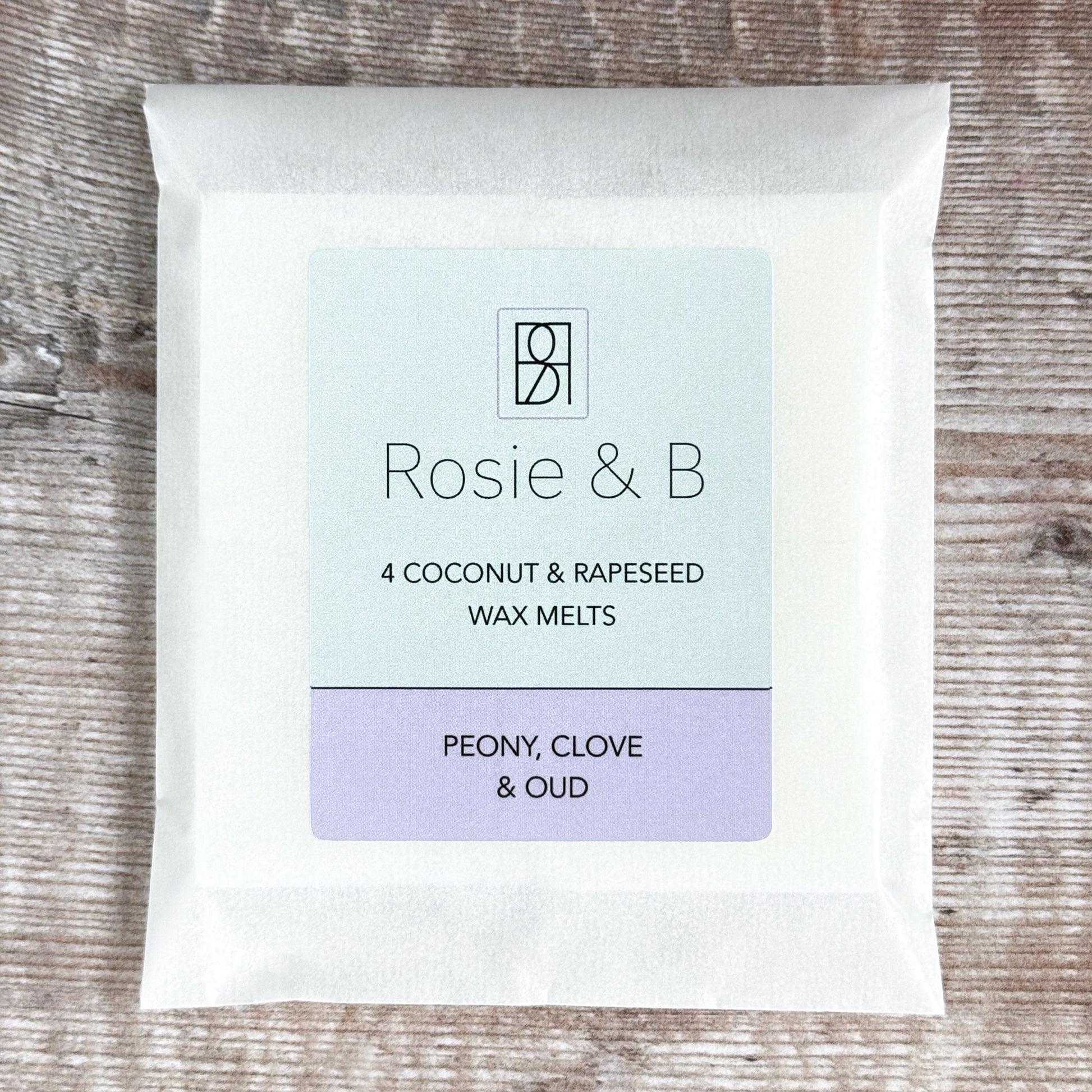 A packet of 4 Peony, Clove & Oud wax melts on a wooden background