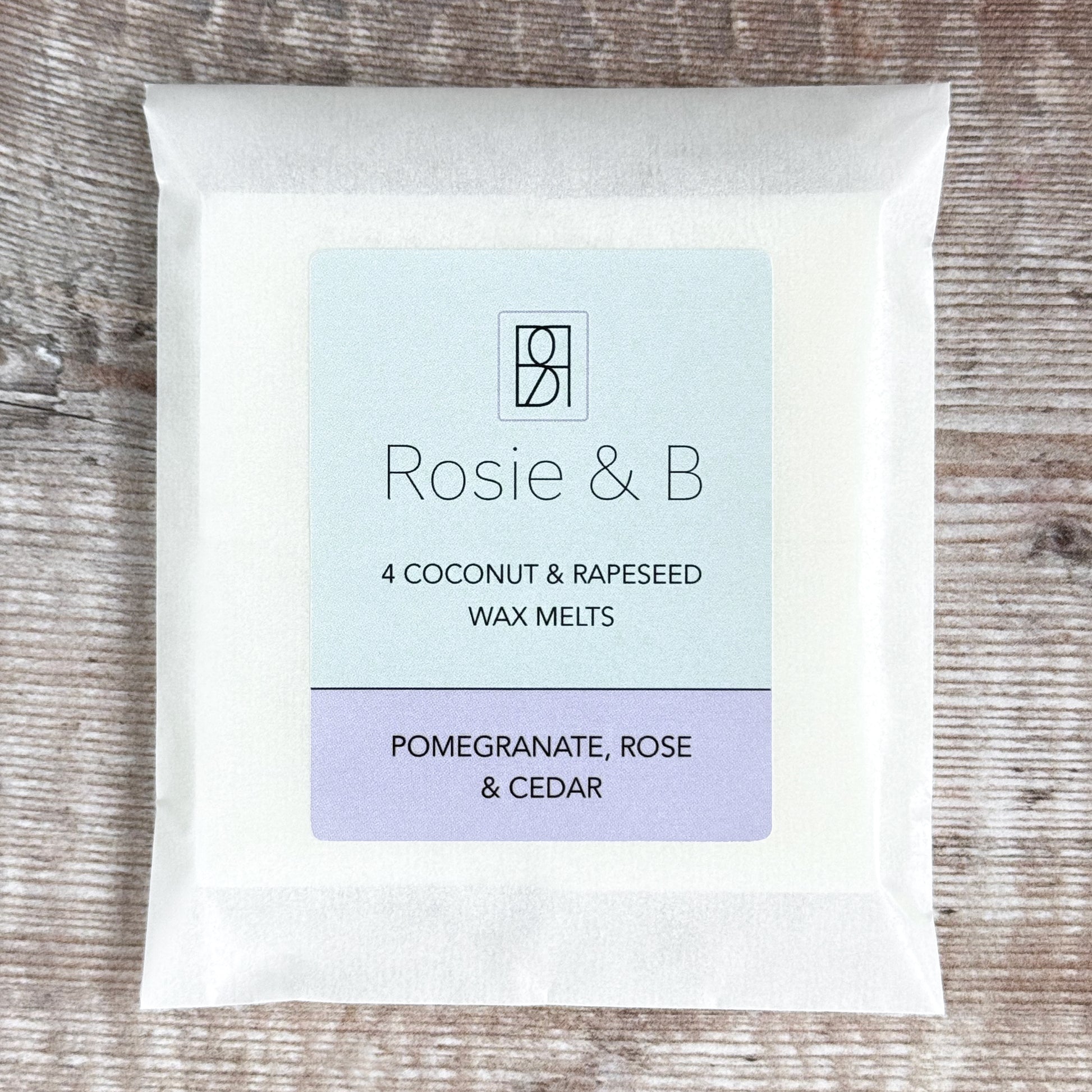 A packet of 4 Pomegranate, Rose & Cedar wax melts on a wooden background